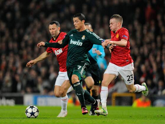 Cristiano Ronaldo of Real Madrid (c) gets between Ryan Giggs and Tom Cleverley of Manchester United - UEFA CHAMPIONS LEAGUE - ROUND OF 16 - Manchester Utd vs Real Madrid - Old Trafford Stadium - Manchester - 05 03 13 - Picture Simon Bellis Sportimage- EDITORIAL USE ONLY. No use with unauthorised audio, video, data, fixture lists, club league logos or live services. Online in-match use limited to 120 images, no video emulation. No use in betting, games or single club league player publications.