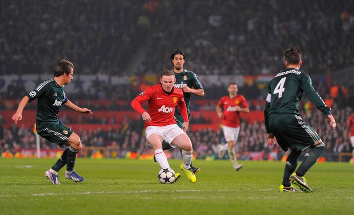 Wayne Rooney of Manchester United surrounded by Real Madrid players - UEFA CHAMPIONS LEAGUE - ROUND OF 16 - Manchester Utd vs Real Madrid - Old Trafford Stadium - Manchester - 05 03 13 - Picture Simon Bellis Sportimage- EDITORIAL USE ONLY. No use with unauthorised audio, video, data, fixture lists, club league logos or live services. Online in-match use limited to 120 images, no video emulation. No use in betting, games or single club league player publications.