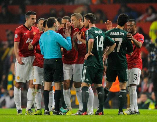 Manchester Utd players surround the referee following his sending off of Nani of Manchester United - UEFA CHAMPIONS LEAGUE - ROUND OF 16 - Manchester Utd vs Real Madrid - Old Trafford Stadium - Manchester - 05 03 13 - Picture Simon Bellis Sportimage- EDITORIAL USE ONLY. No use with unauthorised audio, video, data, fixture lists, club league logos or live services. Online in-match use limited to 120 images, no video emulation. No use in betting, games or single club league player publications.