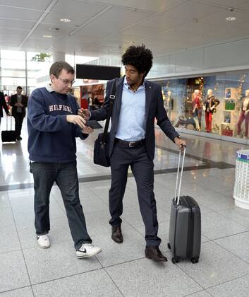09.04.2013, Fussball Champions League Viertelfinale Rückspiel: FC Bayern München - Juventus Turin, Abflug der Mannschaft des FC Bayern am Flughafen München, Dante (re, Bayern) kommt mit seinem Trolley zum Check-In-Schalter.