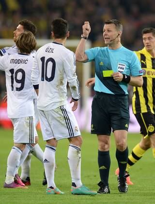 FUSSBALL CHAMPIONS LEAGUE HALBFINALE HINSPIEL 2012 2013 Borussia Dortmund - Real Madrid 24.04.2013 Schiedsrichter Bjoern Kuipers (re) zeigt Mesut Özil (Real Madrid) die Gelbe Karte, als Reaktion auf die Forderung von Özil seinen Gegenspieler zu verwarnen 