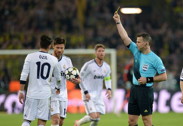 FUSSBALL CHAMPIONS LEAGUE HALBFINALE HINSPIEL 2012 2013 Borussia Dortmund - Real Madrid 24.04.2013 Schiedsrichter Bjoern Kuipers (re) zeigt Mesut Özil (li, Real Madrid) die Gelbe Karte, als Reaktion auf die Forderung von Özil seinen Gegenspieler zu verwarnen 