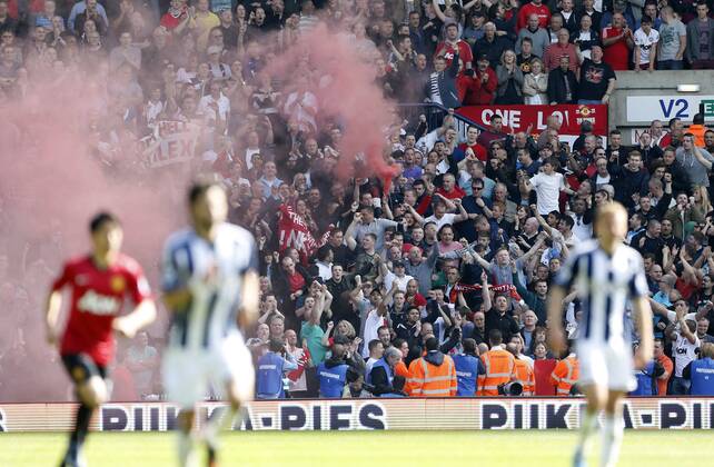Manchester United s fans let off a smoke bomb - Barclays Premier League - Manchester United - The Hawthrowns - West Bromwich - 19 05 2013 - Pic David Klein Sportimage EDITORIAL USE ONLY. No use with unauthorised audio, video, data, fixture lists, club league logos or live services. Online in-match use limited to 120 images, no video emulation. No use in betting, games or single club league player publications.