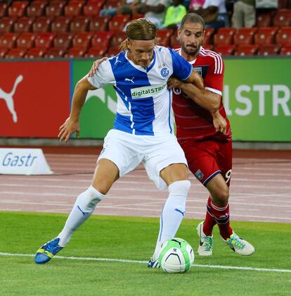 06.08.2013 Zürich Stadion Letzigrund Fussball Herren Saison 2013 2014 Champions-League-Qualifikation Grasshopper Club Zürich - Olympique Lyon Bild zeigt Lisandro Lopez (Lyon) re. gegen Michael Lang (GC) Aktion Zweikampf 