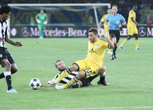 FC Metalist Kharkiv midfielder Sebastian Blanco (yellow kit) and PAOK FC midfielder Dimitris Salpingidis are see on the pitch during the UEFA Champions League third qualifying round second leg fixture at Metalist Stadium, Kharkiv, northeastern Ukraine, August 7, 2013. UKRINFORM. 