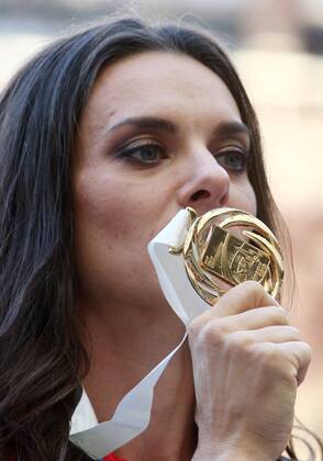 ITAR-TASS: MOSCOW, RUSSIA. AUGUST 15, 2013. Gold medal winner, Russia s Yelena Isinbayeva kisses her medal during the medal ceremony for the women s pole vault final at Luzhniki on Day 6 of the 14th IAAF World Championships in Athletics.  premiumd RE125719