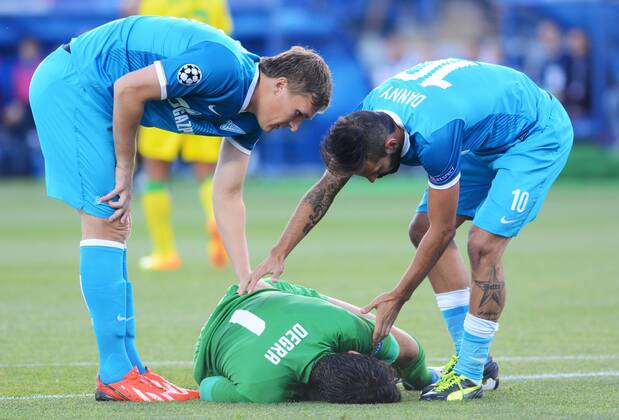 ITAR-TASS: ST PETERSBURG, RUSSIA. AUGUST 28, 2013. Pacos de Ferreira s goalkeeper Matias Omar Degra lays on the ground, Zenitâ€™s Alexander Bukharov (L) and Daniel Miguel (Danny) seen during the UEFA Champions play-off, second leg football match between Zenit St Petersburg and Pacos de Ferreira at Petrovsky stadium.  RE126FF5
