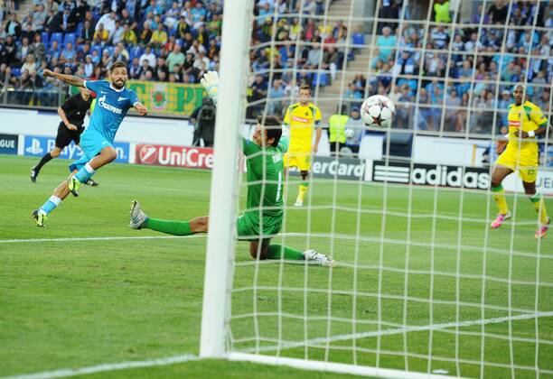 ITAR-TASS: ST PETERSBURG, RUSSIA. AUGUST 28, 2013. Zenit s Daniel Miguel (Danny), left, scores a goal to Pacos de Ferreira s goalkeeper Matias Omar Degra, center, during the UEFA Champions play-off, second leg football match between Zenit St Petersburg and Pacos de Ferreira at Petrovsky stadium.  RE12700C