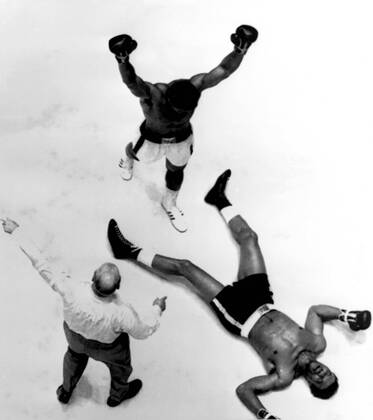 Houston, Texas: Overhead view of the ring in which Cassius Clay (raised arms) beat Cleveland Williams, who lies flat on his back after one of the third round knock-downs. The referee is Harry Kessler. 15th November 1966.  UnitedArchives00926612