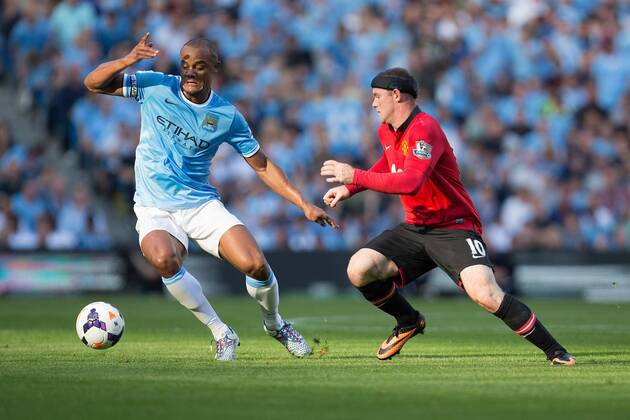 Vincent Kompany of Manchester City and Wayne Rooney of Manchester United in action - Manchester City vs Manchester United - Barclay s Premier League - Etihad Stadium - Manchester - 22 09 2013 EDITORIAL USE ONLY. No use with unauthorised audio, video, data, fixture lists, club league logos or live services. Online in-match use limited to 120 images, no video emulation. No use in betting, games or single club league player publications.
