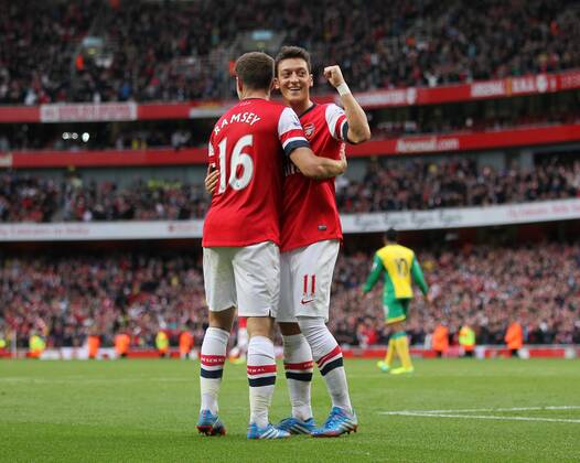 Arsenal s Mesut Ozil celebrates scoring his sides fourth goal with Arsenal s Aaron Ramsey Arsenal FC London v Norwich City - Barclays Premier League - Emirates Stadium - London - England -19 10 2013 - EDITORIAL USE ONLY. No use with unauthorised audio, video, data, fixture lists, club league logos or live services. Online in-match use limited to 120 images, no video emulation. No use in betting, games or single club league player publications.
