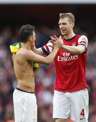 Arsenal s Mesut Ozil celebrates at the final whistle with Per Mertesacker Arsenal FC London v Norwich City - Barclays Premier League - Emirates Stadium - London - England -19 10 2013 - EDITORIAL USE ONLY. No use with unauthorised audio, video, data, fixture lists, club league logos or live services. Online in-match use limited to 120 images, no video emulation. No use in betting, games or single club league player publications.