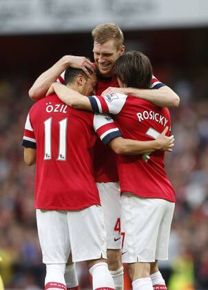 Arsenal s Mesut Ozil celebrates his second goal with Tomas Rosicky and Per Mertesacker Arsenal FC London v Norwich City - Barclays Premier League - Emirates Stadium - London - England -19 10 2013 - EDITORIAL USE ONLY. No use with unauthorised audio, video, data, fixture lists, club league logos or live services. Online in-match use limited to 120 images, no video emulation. No use in betting, games or single club league player publications.