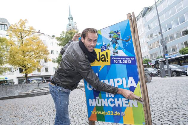 Plakataktion Buergerbegehren pro Olympia 2022, Rindermarkt, München. 22.12.2013 Thomas Muderlak, der Geschäftsführer der BMW Welt, Vorstandssprecher der Tourismus Initiative München, Mitbegründer des Team München 2022 und Sven Hannawald, Skispringer und Rennfahrer kleben Plakate Â