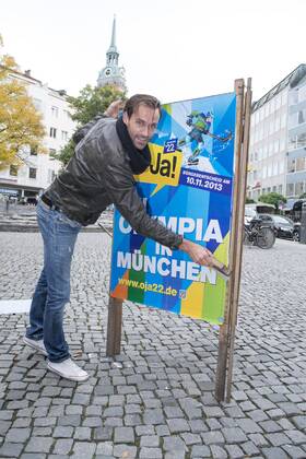 Plakataktion Buergerbegehren pro Olympia 2022, Rindermarkt, München. 22.12.2013 Thomas Muderlak, der Geschäftsführer der BMW Welt, Vorstandssprecher der Tourismus Initiative München, Mitbegründer des Team München 2022 und Sven Hannawald, Skispringer und Rennfahrer kleben Plakate Â