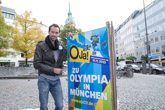 Plakataktion Buergerbegehren pro Olympia 2022, Rindermarkt, München. 22.12.2013 Thomas Muderlak, der Geschäftsführer der BMW Welt, Vorstandssprecher der Tourismus Initiative München, Mitbegründer des Team München 2022 und Sven Hannawald, Skispringer und Rennfahrer kleben Plakate Â