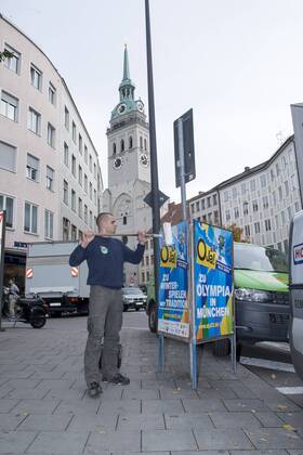 Plakataktion Buergerbegehren pro Olympia 2022, Rindermarkt, München. 22.12.2013 Thomas Muderlak, der Geschäftsführer der BMW Welt, Vorstandssprecher der Tourismus Initiative München, Mitbegründer des Team München 2022 und Sven Hannawald, Skispringer und Rennfahrer kleben Plakate Â