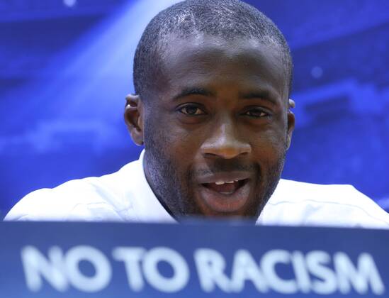 ITAR-TASS: MOSCOW, RUSSIA. OCTOBER 22, 2013. Man. City s midfielder Yaya Toure speaks at a news conference ahead of the first leg of their UEFA Champions League Group S football match against CSKA Moscow. The sign in the foreground reads: no to racism.  RE12D82F