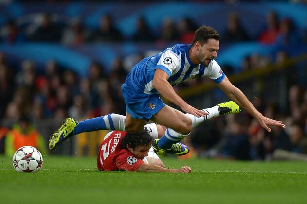 Alberto De La Bella of Real Sociedad tumbles with Rafael of Manchester United - UEFA Champions League Group A - Manchester Utd vs Real Sociedad - Old Trafford Stadium - Manchester - England - 23 10 13 - EDITORIAL USE ONLY. No use with unauthorised audio, video, data, fixture lists, club league logos or live services. Online in-match use limited to 120 images, no video emulation. No use in betting, games or single club league player publications.