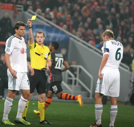 Fussball - Champions League 2013 2014 - Shakhtar Donetsk - Bayer 04 Leverkusen: Sebastian Boenisch bekommt von Schiedsrichter William Collum die gelbe Karte 
