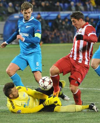 ITAR-TASS: ST PETERSBURG, RUSSIA. NOVEMBER 26, 2013. Zenit s goalie Yuri Lodygin (bottom) and Zenit s Nicolas Lombaerts (L) in action in the UEFA Champions League football match against Atletico Madrid at Petrovsky Stadium. The game ended in a 1:1 draw.  premiumd 20158477