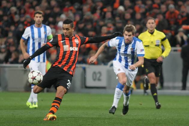 Midfielder Alex Teixeira of FC Shakhtar Donetsk (orange and black kit) kicks the ball during the UEFA Champions League Group A fixture against Real Sociedad San Sebastian at the Donbass Arena, Donetsk, November 27, 2013. 