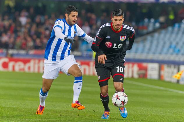 San Sebastian, Spain. 10th December 2013 Real Sociedad s Carlos Vela (11) and Bayer 04 Leverkusen s Emre Can (10) during the UEFA Champions League Group A match between Real Sociedad and Bayer 04 Leverkusen at Anoeta Stadium 