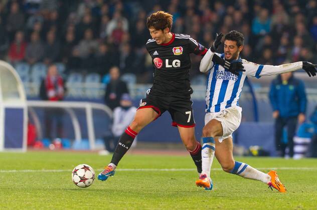 San Sebastian, Spain. 10th December 2013 Bayer 04 Leverkusen s Son Heung-Min (7) and Real Sociedad s Carlos Vela (11) during the UEFA Champions League Group A match between Real Sociedad and Bayer 04 Leverkusen at Anoeta Stadium 