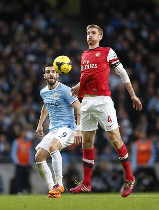 Manchester City s Alvaro Negredo tussles with Arsenal s Per Mertesacker Manchester City vs Arsenal - Premier League - Etihad Stadium - Manchester - England - 14 12 2013 - EDITORIAL USE ONLY. No use with unauthorised audio, video, data, fixture lists, club league logos or live services. Online in-match use limited to 120 images, no video emulation. No use in betting, games or single club league player publications.