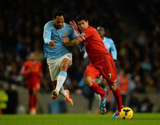 Joleen Lescott of Manchester City tussles with Luis Suarez of Liverpool - Barclays Premier League - Manchester City vs Liverpool - Etihad Stadium - Manchester - England - 26th December 2013 - Picture Simon Bellis Sportimage EDITORIAL USE ONLY. No use with unauthorised audio, video, data, fixture lists, club league logos or live services. Online in-match use limited to 120 images, no video emulation. No use in betting, games or single club league player publications.