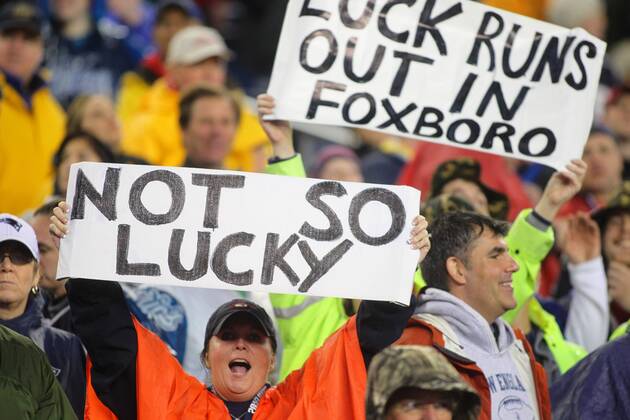New England Patriots fans hold up signs taunting Indianapolis Colts quarterback Andrew Luck (12) in the fourth quarter of the AFC Divisional Playoff game at Gillette Stadium in Foxboro, Massachusetts on January 11, 2014. The Patriots defeated the Colts 43-22.  BOS2014011117