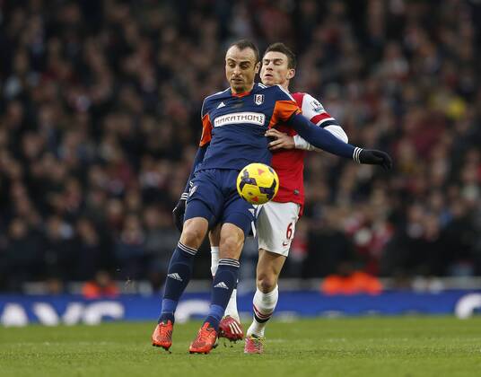 Arsenal s Laurent Koscielny tussles with Fulham s Dimitar Berbatov Arsenal FC London Vs Fulham FC - Premier League - Emirates Stadium- London - England - 18 01 2014 - Pic DavidKlein Sportimage EDITORIAL USE ONLY. No use with unauthorised audio, video, data, fixture lists, club league logos or live services. Online in-match use limited to 120 images, no video emulation. No use in betting, games or single club league player publications.