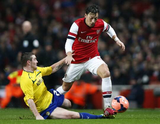LONDON, Jan. 24, 2014 (Xinhua) -- Mesut Ozil (R) of Arsenal vies with John Fleck of Coventry City during FA Cup Fourth Round match between Arsenal and Coventry City at Emirates Stadium in London, Britain on Jan. 24, 2014. 