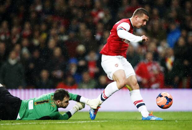 LONDON, Jan. 24, 2014 (Xinhua) -- Lukas Podolski (R) of Arsenal scores his first goal after passing Joe Murphy, the goalie of Coventry City during FA Cup Fourth Round match between Arsenal and Coventry City at Emirates Stadium in London, Britain on Jan. 24, 2014. 