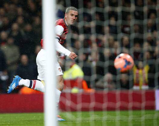 LONDON, Jan. 24, 2014 (Xinhua) -- Lukas Podolski of Arsenal scores his first goal after passing Joe Murphy, the goalie of Coventry City during FA Cup Fourth Round match between Arsenal and Coventry City at Emirates Stadium in London, Britain on Jan. 24, 2014.
