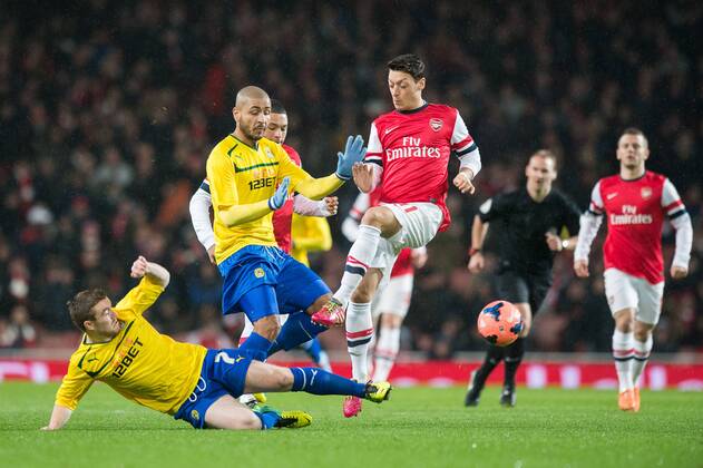 24.01.2014 London, England. Mesut Ozil of Arsenal evades a sliding challenge by John Fleck of Coventry during the FA Cup 4th Round game between Arsenal and Coventry City from the Emirates Stadium. xMikexFrenchx  ActionPlus20166580