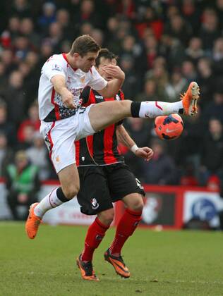 Football - 2013 2014 FA Cup - Fourth Round: AFC Bournemouth vs. FC Liverpool - Jordan Henderson of Liverpool gets to the ball before Bournemouth s Charlie Daniels at Dean Court The Goldsands Stadium -