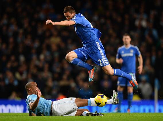 Vincent Kompany of Manchester City catches Nemanja Matic of Chelsea on the shin as he tackles him - Barclays Premier League - Manchester City vs Chelsea FC - Etihad Stadium - Manchester - England - 03rd February 2014 - EDITORIAL USE ONLY. No use with unauthorised audio, video, data, fixture lists, club league logos or live services. Online in-match use limited to 120 images, no video emulation. No use in betting, games or single club league player publications.