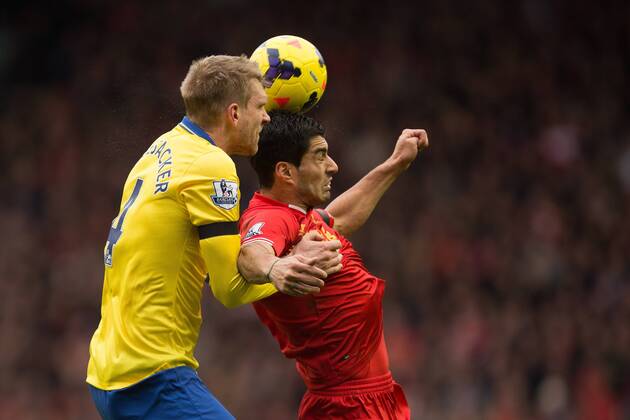Arsenal s Per Mertesacker and Luis Suarez of Liverpool contest a header - Liverpool vs. Arsenal - Barclays Premier League - Anfield - Liverpool - 08 02 2014 Pic Philip Oldham Sportimage EDITORIAL USE ONLY. No use with unauthorised audio, video, data, fixture lists, club league logos or live services. Online in-match use limited to 120 images, no video emulation. No use in betting, games or single club league player publications.