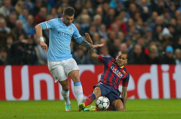 Aleksander Kolarov of Manchester City is tackled by Daniel Alves of Barcelona - UEFA Champions League First Knockout Round - Manchester City vs FC Barcelona - Etihad Stadium - Manchester - England - 18th February 2014 - Picture Dave Thompson Sportimage EDITORIAL USE ONLY. No use with unauthorised audio, video, data, fixture lists, club league logos or live services. Online in-match use limited to 120 images, no video emulation. No use in betting, games or single club league player publications.