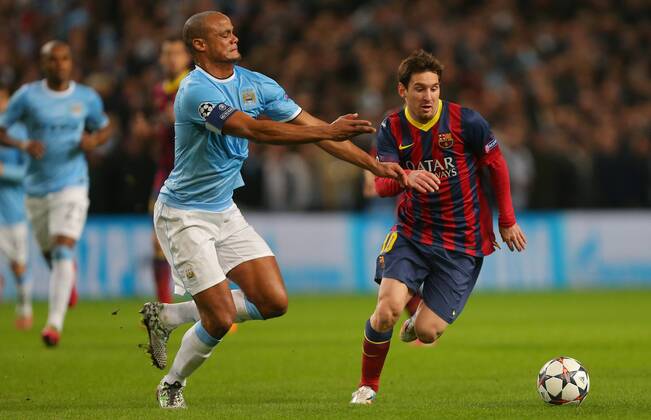 Vincent Kompany of Manchester City challenges Lionel Messi of Barcelona - UEFA Champions League First Knockout Round - Manchester City vs FC Barcelona - Etihad Stadium - Manchester - England - 18th February 2014 - Picture Dave Thompson Sportimage EDITORIAL USE ONLY. No use with unauthorised audio, video, data, fixture lists, club league logos or live services. Online in-match use limited to 120 images, no video emulation. No use in betting, games or single club league player publications.