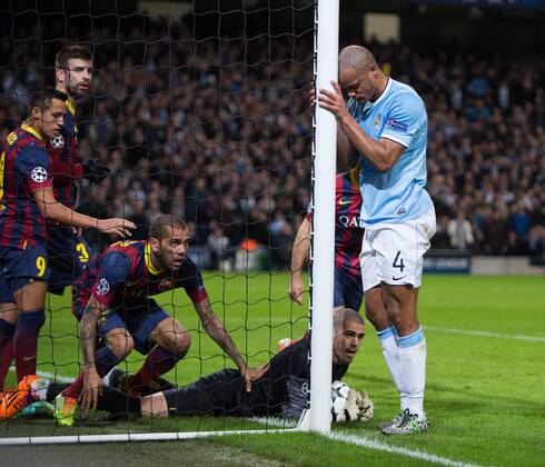 Vincent Kompany of Manchester City looks dejected as Victor Valdes of Barcelona secures the ball - UEFA Champions League First Knockout Round - Manchester City vs Barcelona - Etihad Stadium - Manchester - England - 18th February 2014 - Picture Phil Oldham Sportimage EDITORIAL USE ONLY. No use with unauthorised audio, video, data, fixture lists, club league logos or live services. Online in-match use limited to 120 images, no video emulation. No use in betting, games or single club league player publications.