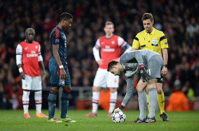 FUSSBALL CHAMPIONS LEAGUE ACHTELFINALE HINSPIEL SAISON 2013 2014 Arsenal London - FC Bayern München 19.02.2014 Torwart Lukasz Fabianski (re, Arsenal) legt David Alaba (li, FC Bayern München) vor dem Elfmeter den Ball zurecht. Schiedsrichter Nicola Rozzoli ist Beobachter dieser Szene 