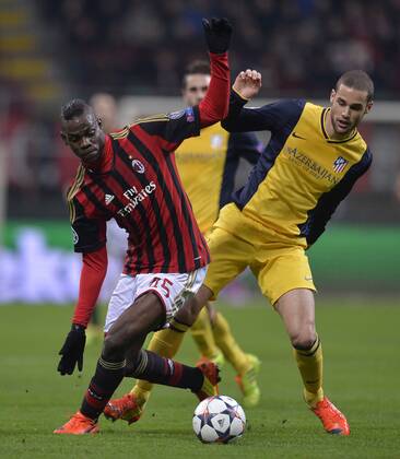 (140220) -- MILAN, Feb. 19, 2014 (Xinhua) -- AC Milan s Mario Balotelli (L) challenges Atletico Madrid s Mario Suarez during their Champions League round of 16 first leg soccer match in Milan, Italy, Feb. 19, 2014. Atletico Madrid won 1-0. (Xinhua Alberto Lingria) (SP)ITALY-MILAN-CHAMPIONS LEAGUE-AC MILAN VS ATLETICO MADRID 