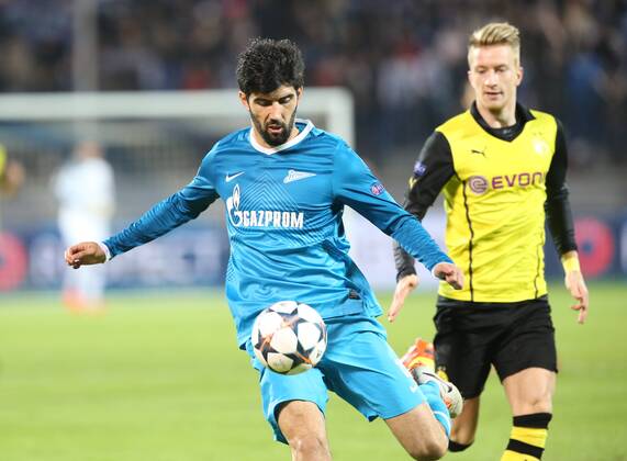 ITAR-TASS: ST PETERSBURG, RUSSIA. FEBRUARY 25, 2014. Zenit St Petersburg s Luis Neto (L) handles the ball under pressure from Borussia Dortmund s Marco Reus in their UEFA Champions League Round of Last 16 football match at Petrovsky Stadium.  RE13B037