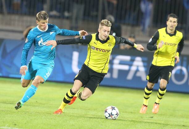 ITAR-TASS: ST PETERSBURG, RUSSIA. FEBRUARY 25, 2014. Borussia Dortmund s Marco Reus (C) runs with the ball under pressure from Zenit St Petersburg s Andrei Arshavin (L) in their UEFA Champions League Round of Last 16 football match at Petrovsky Stadium.  RE13B03F