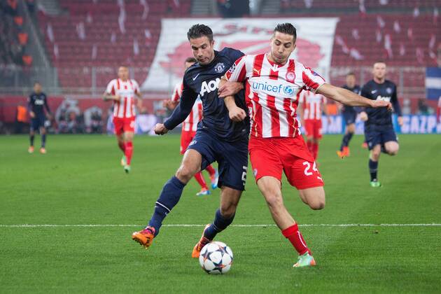 Robin van Persie of Manchester United battles Kostas Manolas of Olympiacos - UEFA Champions League First Knockout Round - Olympiacos vs. Manchester United - Karaiskakh Stadium - Athens - Greece - 25th February 2014 - EDITORIAL USE ONLY. No use with unauthorised audio, video, data, fixture lists, club league logos or live services. Online in-match use limited to 120 images, no video emulation. No use in betting, games or single club league player publications.