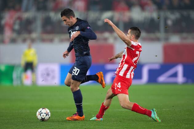Robin van Persie of Manchester United skips past Kostas Manolas of Olympiacos - UEFA Champions League First Knockout Round - Olympiacos Piräus vs. Manchester United (ManU) - Karaiskakh Stadium - Athens - 25th February 2014 - EDITORIAL USE ONLY. No use with unauthorised audio, video, data, fixture lists, club league logos or live services. Online in-match use limited to 120 images, no video emulation. No use in betting, games or single club league player publications.