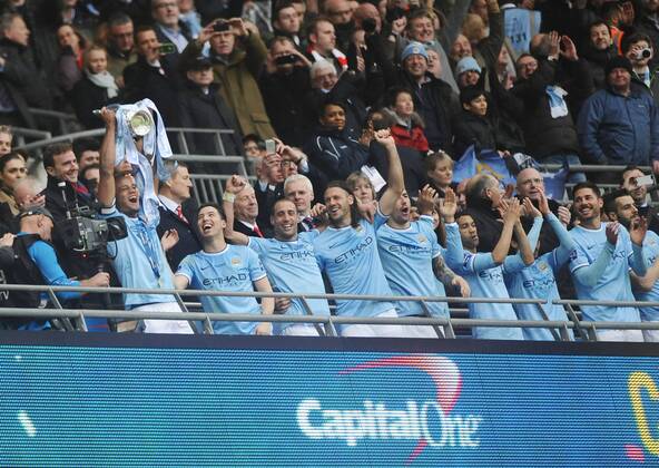 Football - 2014 Capital One League Cup Final - Manchester City vs. AFC Sunderland FC - City s Vincent Kompany lifts the Trophy with team mates at Wembley. 