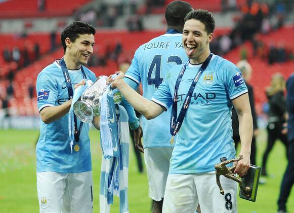 Football - 2014 Capital One League Cup Final - Manchester City vs. AFC Sunderland FC - City s Jesus Navas and Samir Nasri celebrate with the trophy at Wembley. 